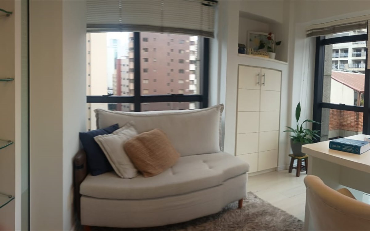 Sala de atendimento com sofá e vista para a cidade